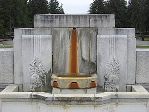 Pierre d'une ancienne fontaine tachée de rouille.