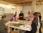 La photo montre une restauratrice du Centre de conservation du Québec donnant une formation à un groupe de personnes sur les différentes structures de la reliure