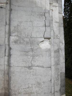 Détail du socle d'une oeuvre de 1947 qui montre plusieurs symptômes de dégradation : faïençage, éclatement, formation de fentes et de fissures.